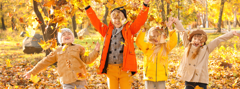 Kids Playing In Autumn Leaves